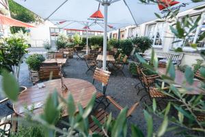 an outdoor patio with tables and chairs and umbrellas at Gästehaus Korf in Unkel +52 photos