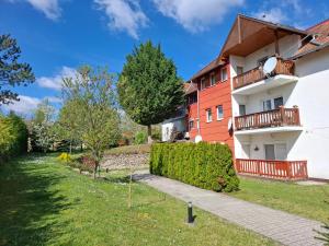 an apartment building with a garden in front of it at Mézi Lazy in Gyenesdiás