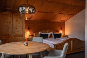 a bedroom with a bed and a table and chairs at Das Tannacker - Ferienwohnungen Hartmann in Fischen