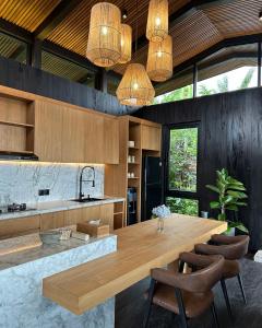 a kitchen with a large wooden table and chairs at The Bataran Cabin in Gitgit