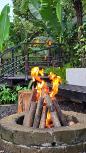a fire pit in a park with flames at The Bataran Cabin in Gitgit