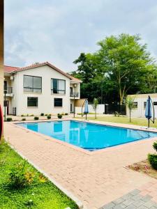 a swimming pool in front of a house at SouthSide Apartment in Gaborone