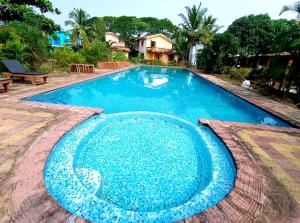 a large swimming pool with blue water at Kinara 2 bhk Villa in Varca