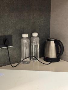two glass bottles on a counter next to a tea kettle at Shagun Stays in Greater Noida +3 photos