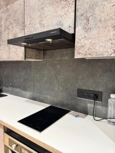 a kitchen with a black hood over a kitchen counter at Shagun Stays in Greater Noida