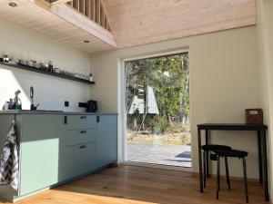 a kitchen with a counter and a table and a door at Uduaasa Minimaja in Urge