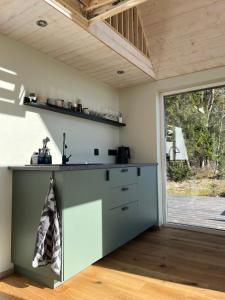 a kitchen with a counter with a sink and a window at Uduaasa Minimaja in Urge +9 photos