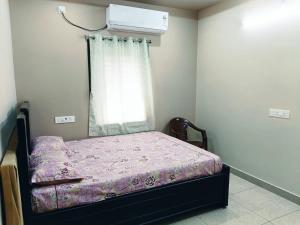 a small bedroom with a bed and a window at Sri Datta Paduka Nivas in Pithāpuram