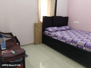 a small bedroom with a bed and a chair at Sri Datta Paduka Nivas in Pithāpuram