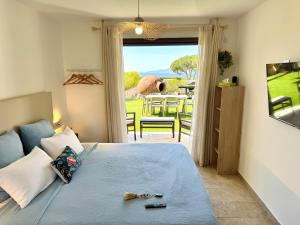 a bedroom with a bed with a view of a patio at Domaine LUMISTELLA in Porticcio +14 photos