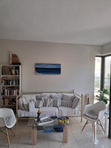a living room with a couch and two chairs at Elia Studios in Palekastron