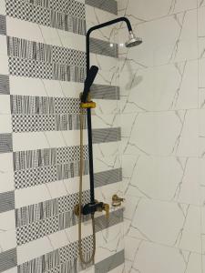 a shower with a shower head in a bathroom at Nuva Hotel in Islamabad +65 photos