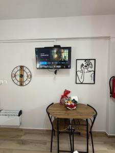 a room with a table and a tv on a wall at The Small apartment Papa Nero Pelion in Agios Ioannis Pelio