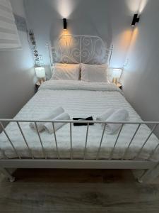 a white bed with a metal frame in a bedroom at The Small apartment Papa Nero Pelion in Agios Ioannis Pelio +13 photos