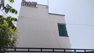 a white building with a sign on the side of it at jAYESH PALACE in Loni Kālbhor