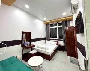 a room with a bed and a table and a couch at Khách sạn Vân Nhi in Bạc Liêu