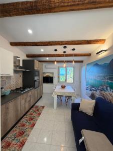 a kitchen and living room with a blue couch and a table at Scopello Guidaloca Villas in Scopello