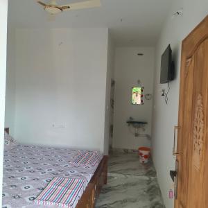 a bedroom with a bed and a flat screen tv at Durga Residency in Alāndurai