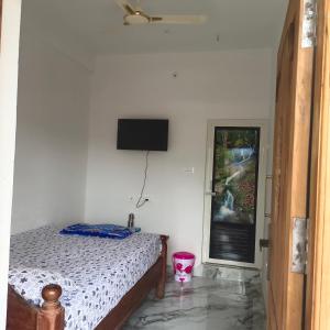 a bedroom with a bed and a television on the wall at Durga Residency in Alāndurai