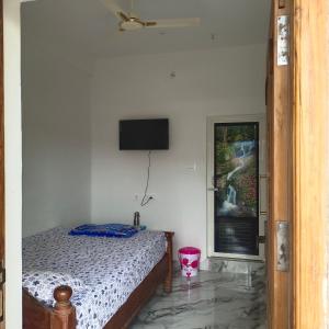 a bedroom with a bed and a television on the wall at Durga Residency in Alāndurai