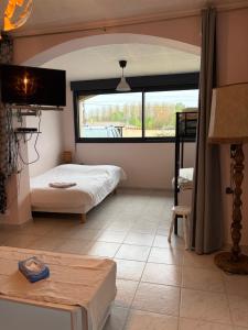 a bedroom with a bed and a large window at Gite Esprit Etape in Saint-Barthélemy-de-Vals