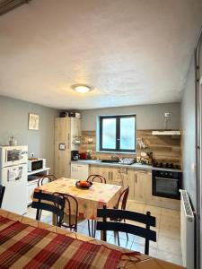 a kitchen with a table and chairs in a room at Gite Esprit Etape in Saint-Barthélemy-de-Vals