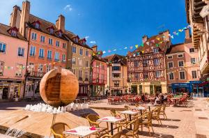 a city street with tables and chairs and buildings at Beau duplex lumineux avec balcon in Chalon-sur-Saône