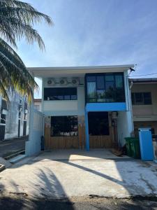 a house with a palm tree in front of it at Puzzle House in Taiping