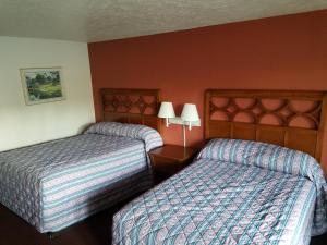 a hotel room with two beds and two lamps at Masters Inn I-26 in Cayce