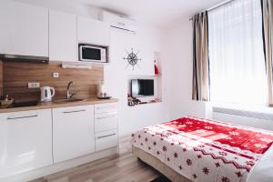 a white kitchen with a bed and a sink at Apartments Borna in Zagreb