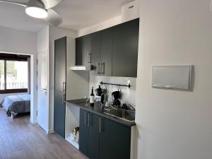 a kitchen with black cabinets and a sink at Seamount, studio 3 mins from Tamariu beach in Tamariu +4 photos
