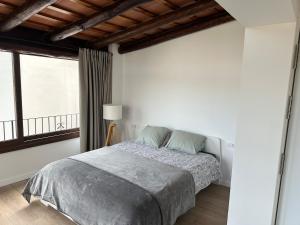 a white bedroom with a bed and a window at Seamount, studio 3 mins from Tamariu beach in Tamariu
