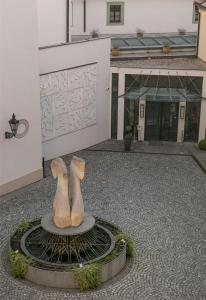 a statue of two people sitting on a circle in front of a building at Augustine Hotel, Prague in Prague +268 photos