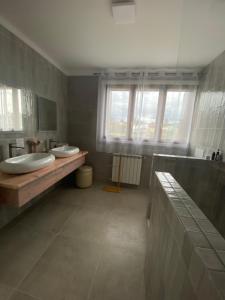 a bathroom with two sinks and a large window at A casa das hortênsias- caminho de Santiago in São Pedro da Torre