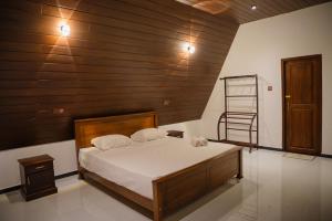 a bedroom with a bed with a wooden wall at King coco villa in Tangalle +20 photos