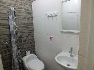 a small bathroom with a toilet and a sink at Hostal Gazu in Chiclayo