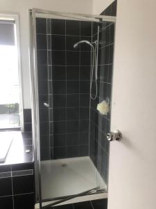 a bathroom with a shower with a glass door at Manors Bvld in Wyndham Vale