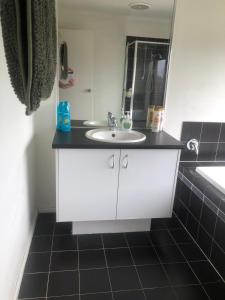 a bathroom with a white sink and a mirror at Manors Bvld in Wyndham Vale