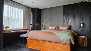 a bedroom with a bed and a desk and a chair at The Bataran Studio in Gitgit