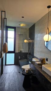 a bathroom with a tub and a toilet and a sink at The Bataran Studio in Gitgit