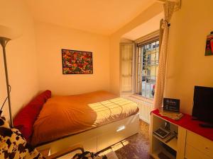 a small bedroom with a bed and a window at Friendly Africa Room Como Center in Como +5 photos