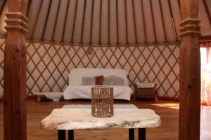 a room with a bed and a table in a yurt at Jurta Les Park in Vřesovice