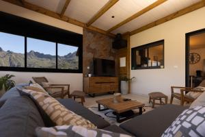 a living room with a couch and a tv at Le Cilodge - La Villa Lodge au cœur de Cilaos in Cilaos