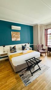 a bedroom with a large bed and a blue wall at Hidden Villas Guesthouse in East London +23 photos