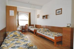 a bedroom with two beds and a dresser and a window at Przystań u Kapitana in Ustka