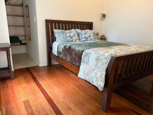 a bedroom with a large bed with a wooden floor at Lemon Cottage in Rous Mill