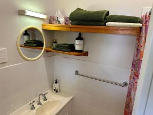 a bathroom with a sink and a mirror at Lemon Cottage in Rous Mill +24 photos