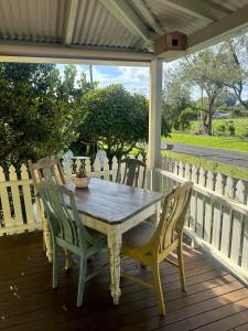 a wooden table and chairs on a porch at Lemon Cottage in Rous Mill