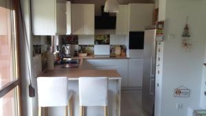 a kitchen with white cabinets and a white refrigerator at Familienurlaub am See - Haus nr 1 - Rokitki in Rokitki