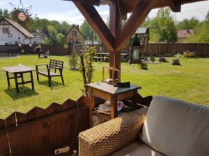 a patio with a table and chairs and a grass yard at Familienurlaub am See - Haus nr 1 - Rokitki in Rokitki